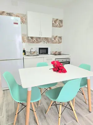 a kitchen with a white table and blue chairs at La Casita de Beni Valencia in Valencia