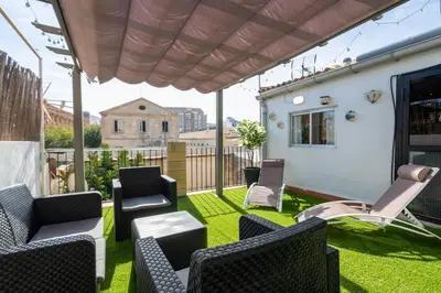 a patio with chairs and a table on grass at ChillOut Area 2BR 4P City Relax Fast WiFi Pet Friendly in Valencia