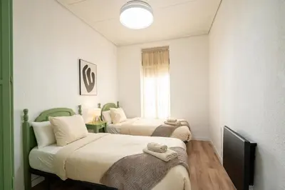 two beds in a small room with a window at ChillOut Area 2BR 4P City Relax Fast WiFi Pet Friendly in Valencia