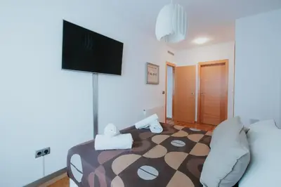 a bedroom with a bed with a flat screen tv on the wall at Family & Friends Apartment with Pool in Torrent