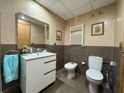 a bathroom with a toilet and a sink and a mirror at Family & Friends Apartment with Pool in Torrent
