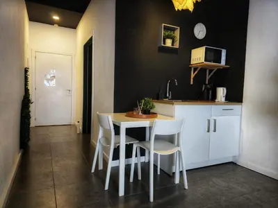 a kitchen with a table and some white chairs at Cozy Room G20 in Valencia