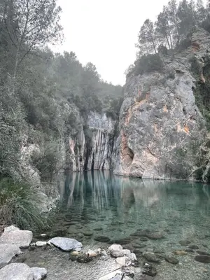 a body of water with rocks and a mountain at Villa punta RJ in Pavías