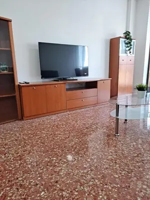 a living room with a flat screen tv and a table at Comfortable apartment in the Feria 2 area in Valencia