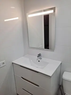 a white bathroom with a sink and a mirror at Comfortable apartment in the Feria 2 area in Valencia