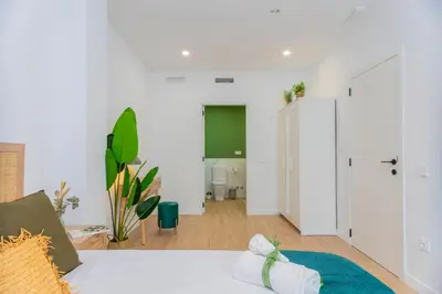 a living room with a white couch and a hallway at - Marés Cabanyal -Mediterráneo en clave boutique in Valencia