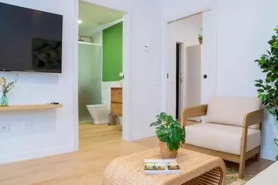 a living room with a chair and a table at - Marés Cabanyal -Mediterráneo en clave boutique in Valencia