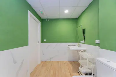 a bathroom with a sink and a green wall at - Marés Cabanyal -Mediterráneo en clave boutique in Valencia