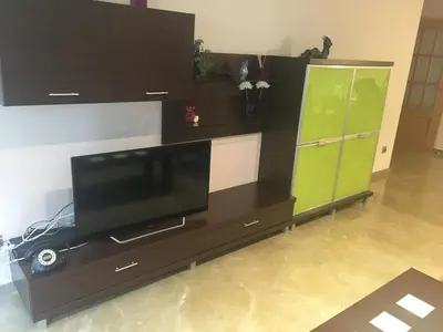 a entertainment center with a television and a green cabinet at Great apartment in Sciences City in Valencia