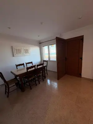 a dining room with a wooden table and chairs at Apartamento en Primera Linea de Playa en Mareny de Barraquetes-Vistas al Mar-El Refugio del Mediterráneo in Mareny Barraquetas