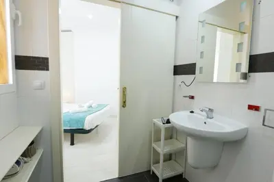 a bathroom with a sink and a mirror and a bed at Apartment Ruzafa Market 7D in Valencia