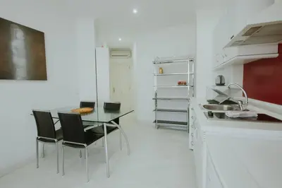 a white kitchen with a table and chairs in it at Apartment Ruzafa Market 7D in Valencia