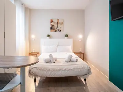 a bedroom with a white bed and a table at Apartment Ruzafa Market 8A in Valencia