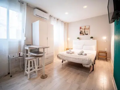 a bedroom with a bed and a table and a desk at Apartment Ruzafa Market 8A in Valencia
