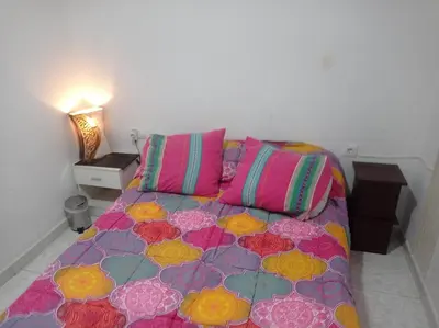 a bedroom with a bed with colorful sheets and pillows at Valencia 2 en piso familiar compartido in Valencia