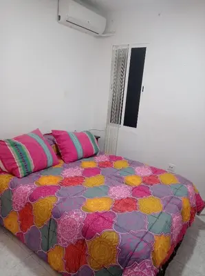 a bed with a colorful comforter in a room at Valencia 2 en piso familiar compartido in Valencia