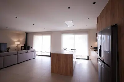 a large kitchen with a refrigerator and a counter at Casa unifamiliar con jardín en la playa in Mareny Blau