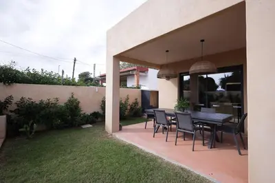 a patio with a table and chairs in a backyard at Casa unifamiliar con jardín en la playa in Mareny Blau