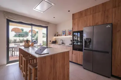 a kitchen with a stainless steel refrigerator and a counter at Casa unifamiliar con jardín en la playa in Mareny Blau