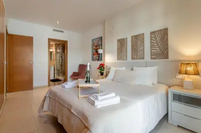 a bedroom with a white bed with a side table at Valencia Beach Vibe - Oceanfront escape in Valencia