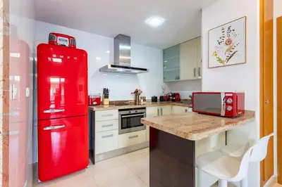 a red refrigerator in a kitchen with a counter at Valencia Beach Vibe - Oceanfront escape in Valencia
