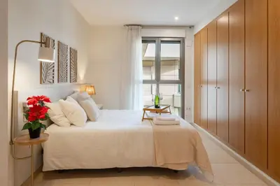 a bedroom with a large bed and a window at Valencia Beach Vibe - Oceanfront escape in Valencia