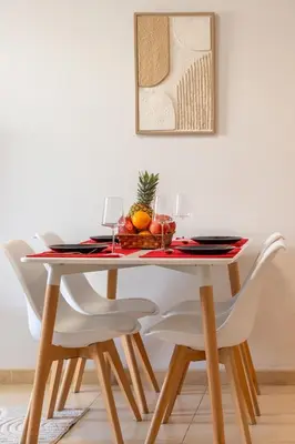 a dining room table with white chairs and a bowl of fruit at Valencia Beach Vibe - Oceanfront escape in Valencia