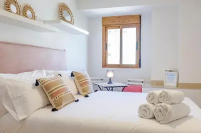 a bedroom with a white bed with towels on it at Gatova Sunset Retreat in Gátova