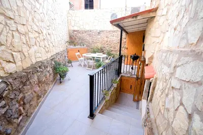 an outdoor patio with a table and a stone wall at En el corazón de Sagunto in Sagunto