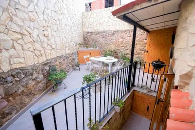 a balcony with a table and chairs and a stone wall at En el corazón de Sagunto in Sagunto