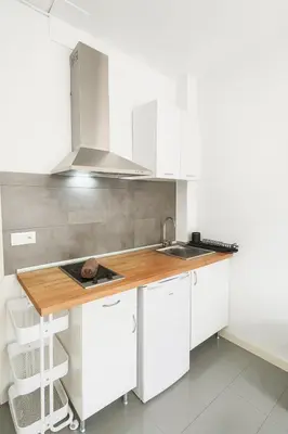 a kitchen with white cabinets and a wooden counter top at Your Apartment In The Center-Ruzafa 8C in Valencia