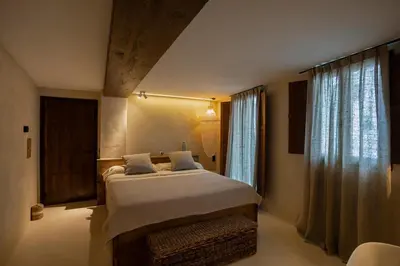 a bedroom with a large bed and two windows at Espacio Biocompatible - Villa Raíz in Requena