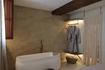 a bathroom with a white bath tub and a robe at Espacio Biocompatible - Villa Raíz in Requena