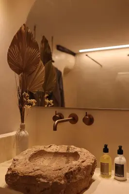 a rock sitting on a counter next to a bathroom sink at Espacio Biocompatible - Villa Raíz in Requena