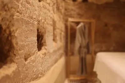 a stone wall with a mirror and a vase at Espacio Biocompatible - Villa Raíz in Requena