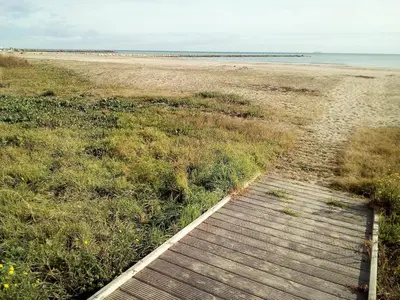 a wooden boardwalk leading to a sandy beach at Pobla de Farnals BEACH APARTMENT in Puebla de Farnals