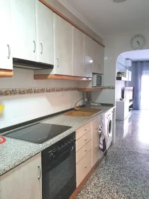 a kitchen with white cabinets and a sink and a dishwasher at Pobla de Farnals BEACH APARTMENT in Puebla de Farnals