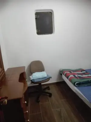 a room with a chair and a bed and a tv at Beach apartment in Valencia