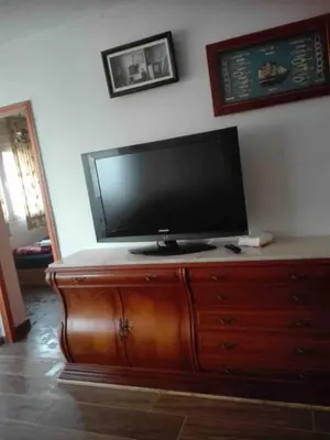 a flat screen tv sitting on top of a wooden dresser at Beach apartment in Valencia