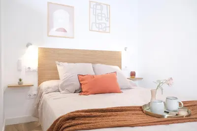 a bedroom with a large bed with an orange pillow at Suite near to Marathon - City of Arts & Sciences in Valencia