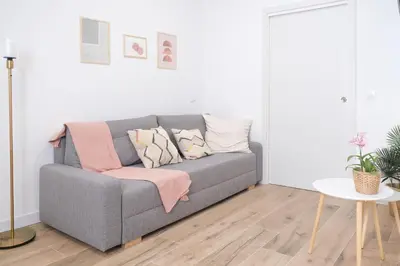 a living room with a gray couch with pillows at Suite near to Marathon - City of Arts & Sciences in Valencia