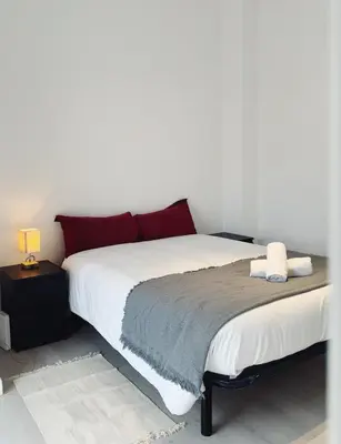 a bedroom with a large white bed with red pillows at Apartment Ruzafa Market 9B in Valencia