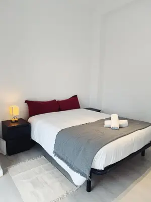 a bedroom with a large white bed with red pillows at Apartment Ruzafa Market 9B in Valencia