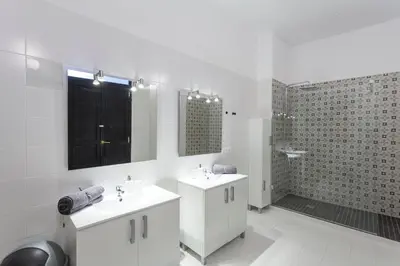 a white bathroom with two sinks and a shower at Apartment 2 bedroom Historical Center in Valencia