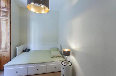 a small bedroom with a bed and a lamp at Apartment 2 bedroom Historical Center in Valencia