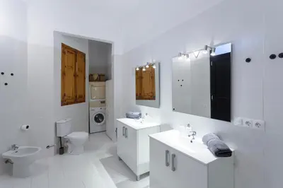 a white bathroom with two sinks and a toilet at Apartment 2 bedroom Historical Center in Valencia