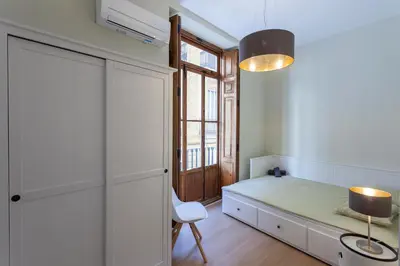 a bedroom with a bed and a desk and a window at Apartment 2 bedroom Historical Center in Valencia