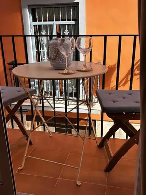 a small table with two wine glasses on a balcony at Estudio recién decorado en el mejor centro histórico in Valencia