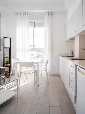 a white kitchen with a white table and chairs at Apartment Ruzafa Market 9C in Valencia