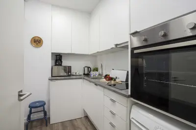 a kitchen with white cabinets and a black microwave at Quart Apartment in Valencia